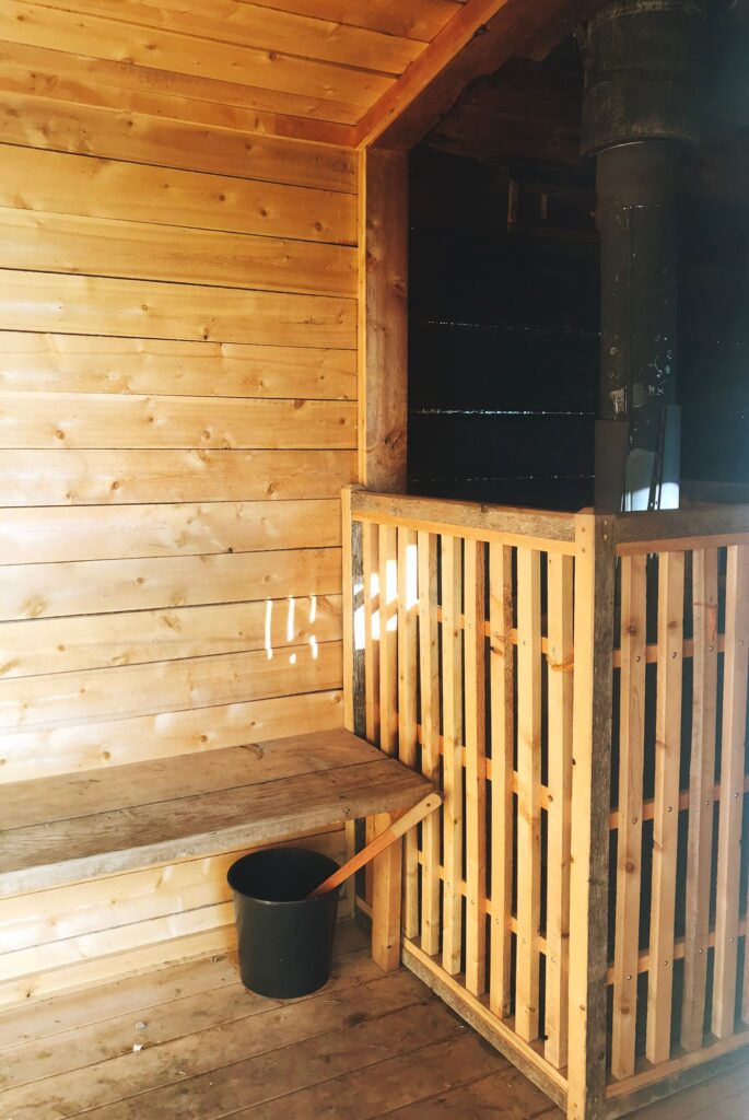 Cedar-lined interior with the bench and the stove beyond the screen