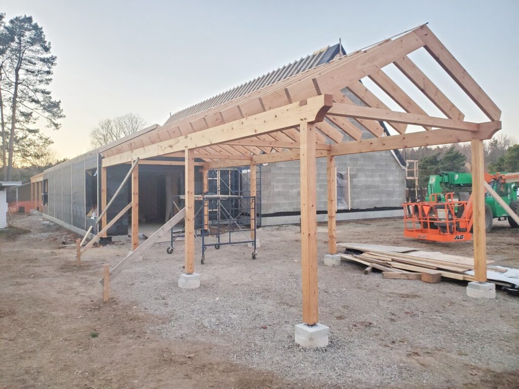 The porch frame standing on site at dusk